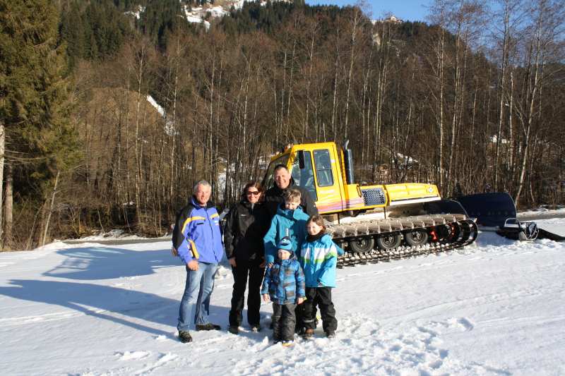 Familie vor dem Pistenbully