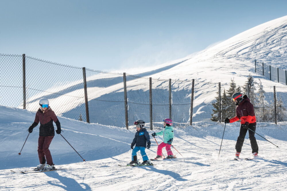 Familie mit zwei kleinen Kindern auf der Piste in Großarl.