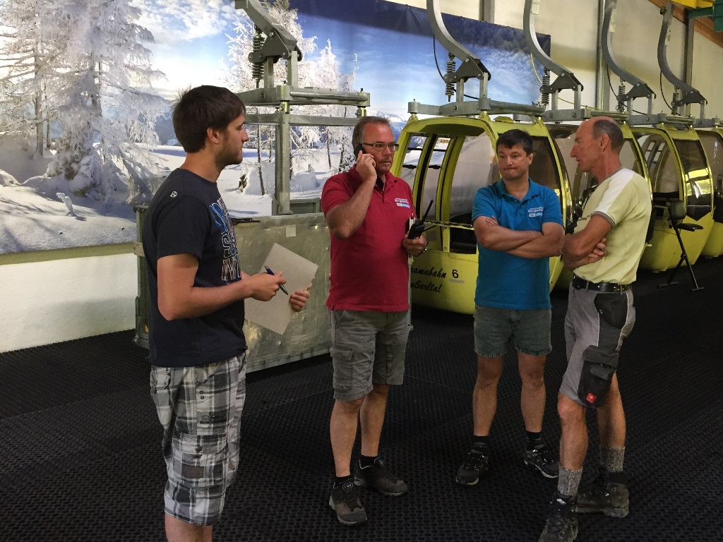 Besprechung der Arbeitseinteilung (vlnr): Assistent Felix, Betriebsleiter Alois, Betriebsleiter Florian, Pistenchef Sepp