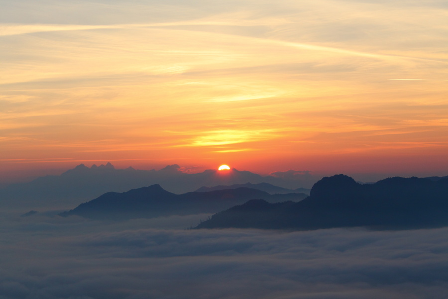 Die Sonne kommt, das Tal schläft unter einer dicken Nebeldecke